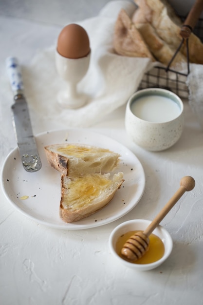 Plaat van toast met honing ei melk ontbijt foto van hoge kwaliteit