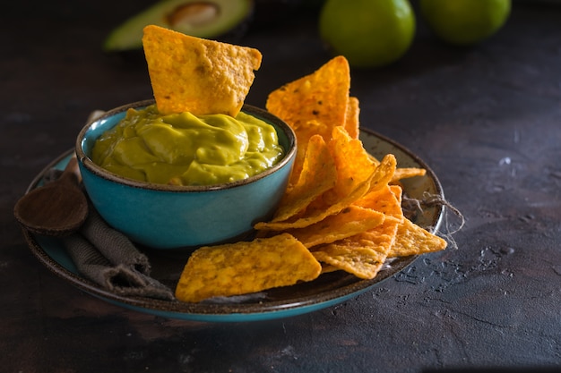 Plaat van zelfgemaakte guacamole met nacho&#39;s.