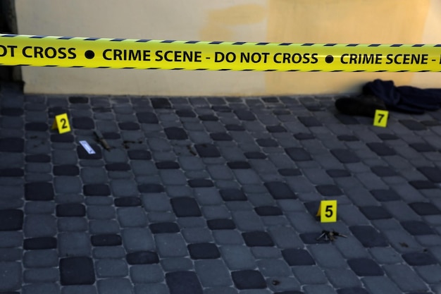 Plaats delict tape voor het bedekken van het gebiedscordon Gele tape met wazige forensische wetshandhavingsachtergrond in filmische toon