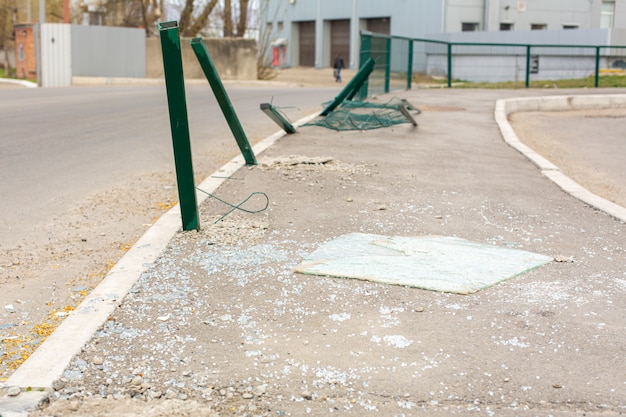 Place of accident on the street. Bent pillars and broken car glass on the road