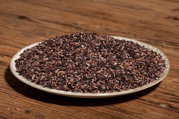 Place the black rice in the plate or bowl on the wood grain table