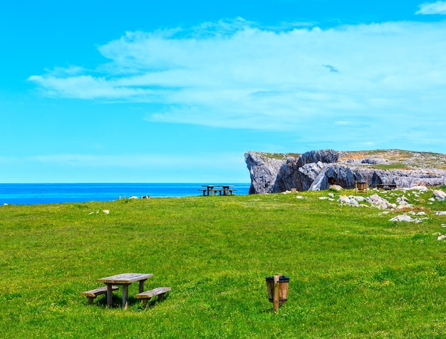 Place of rest (table with benches) on summer blossoming coast near Camango, Asturias (Spain). Two shots stitch image.