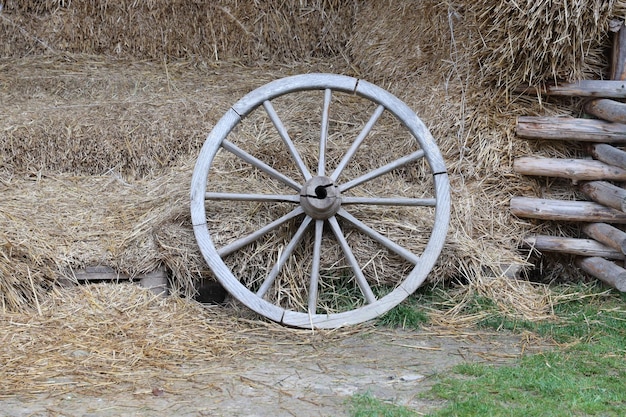 Place with stacks of hay cubes and rustic wooden wheels of old cart