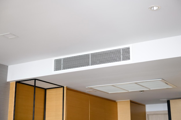 Plafond gemonteerde cassette type airconditioner en modern lamplicht op witte plafondkanaal airconditioner voor thuis of op kantoor;