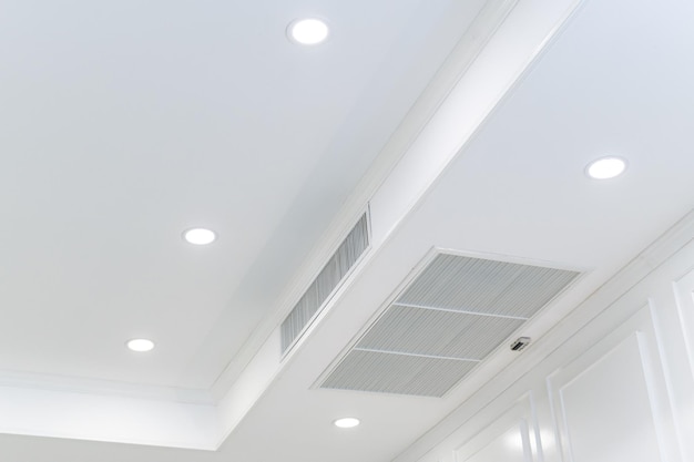 Plafond gemonteerde cassette type airconditioner en modern lamplicht op witte plafondkanaal airconditioner voor thuis of op kantoor;