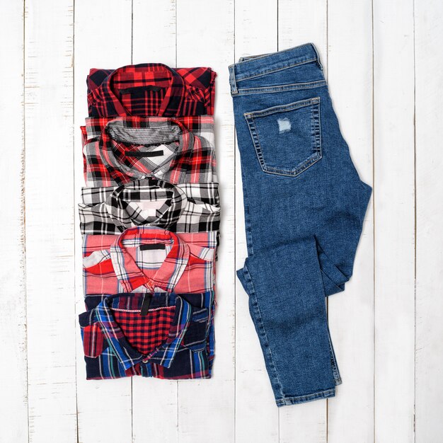 Plaid shirts and blue jeans on a white wooden background