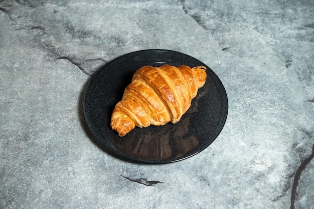 Plain Croissant geserveerd op een bord geïsoleerd op de achtergrond top view van gebakken voedsel Indiase dessert