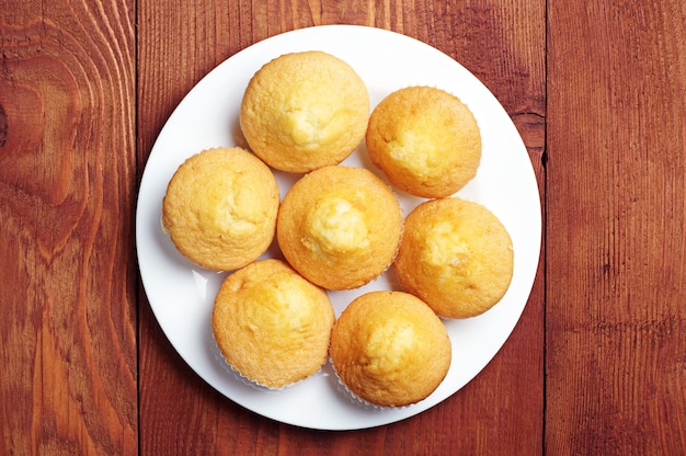 Plain cupcakes on a white plate on table