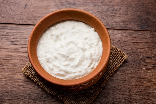 Plain curd or yogurt or Dahi in Hindi, served in a bowl over moody background. Selective focus