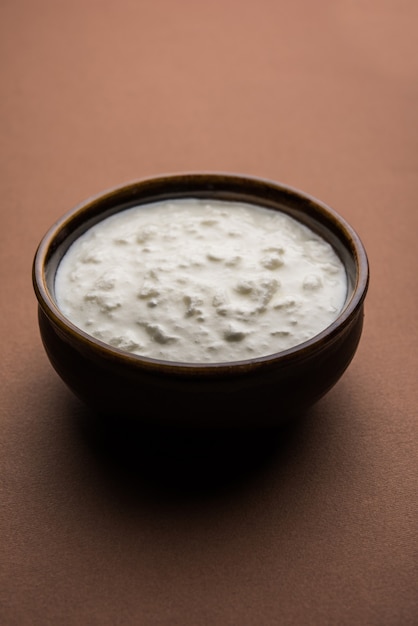 Обычный творог или йогурт, или дахи на хинди, подается в миске на мрачном фоне. Выборочный фокус