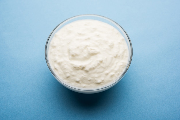 Plain curd or yogurt or Dahi in Hindi, served in a bowl over moody background. Selective focus