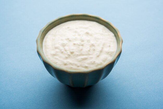 Plain curd or yogurt or Dahi in Hindi, served in a bowl over moody background. Selective focus