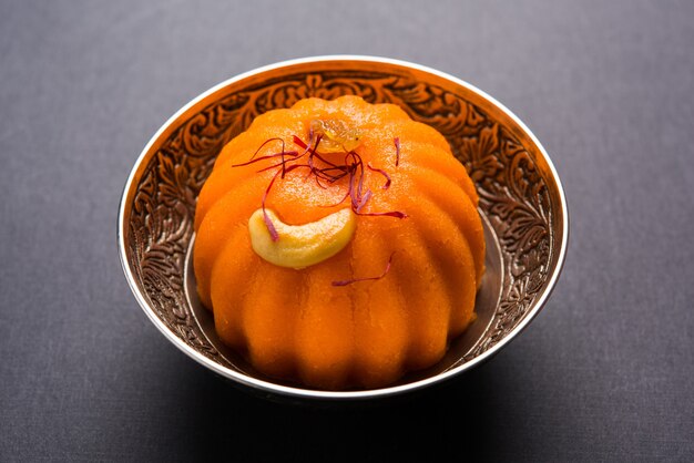 Plain or Saffron flavoured Semolina or Soji Halwa also known as Sweet Rava Sheera OR Shira - Indian festival sweet garnished with dry fruits. Served in a plate or Bowl, selective focus