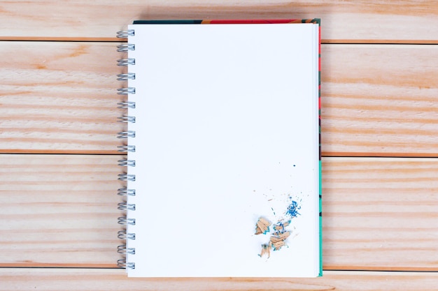 Plain white notepad on a wooden background with traces of pencil