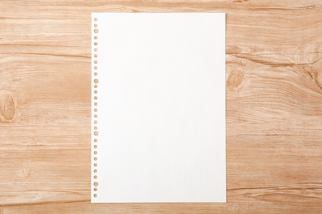 Foto un semplice libro bianco posto su una tavola di legno
