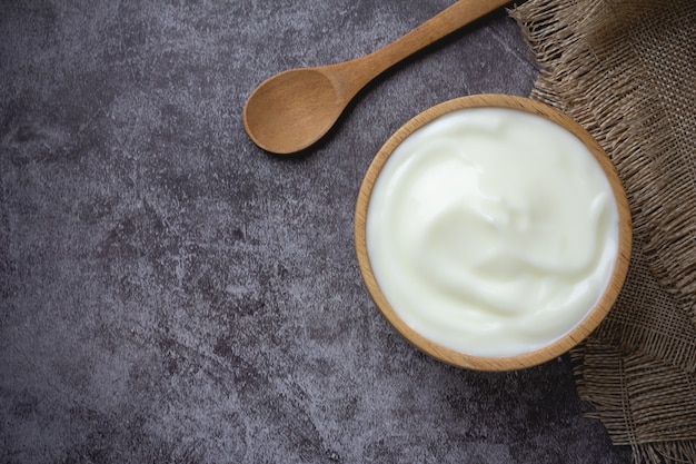 Yogurt normale in ciotola di legno sul tavolo