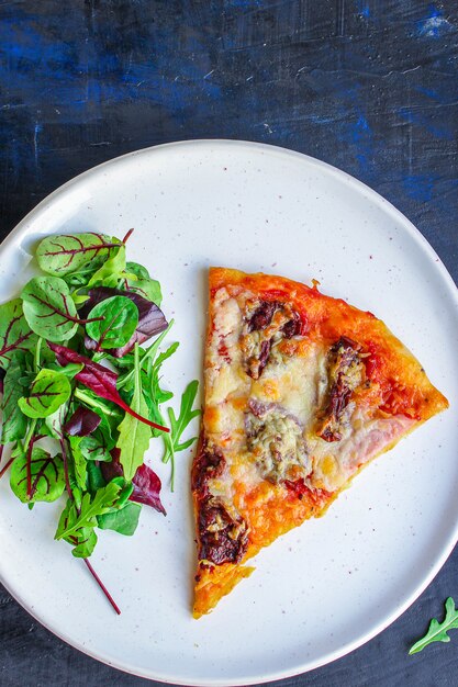 plak van pizza en saladebladeren in een plaat