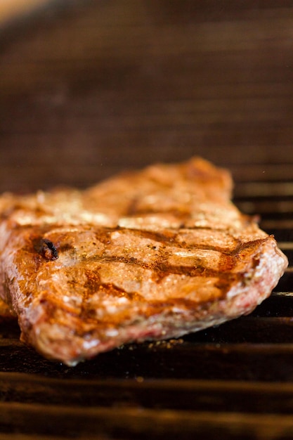 Plak van rundvlees op barbecuegrill.