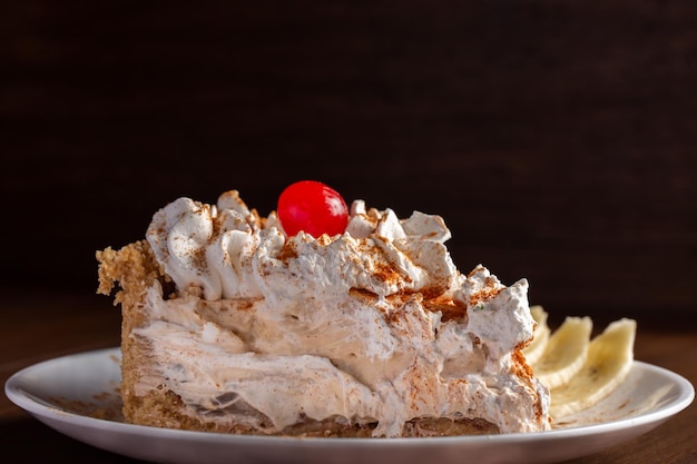 Plakje Banoffee Cake met bananenvulling en karamelsaus. Traditionele Engelse taart