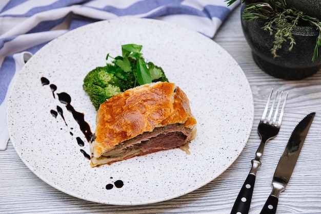 Plakje beef wellington met gestoomde broccoli gekleed met de dikke druppels balsamicosaus