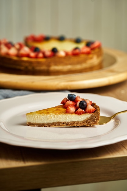 Plakje cheesecake op plaat. Houten achtergrond