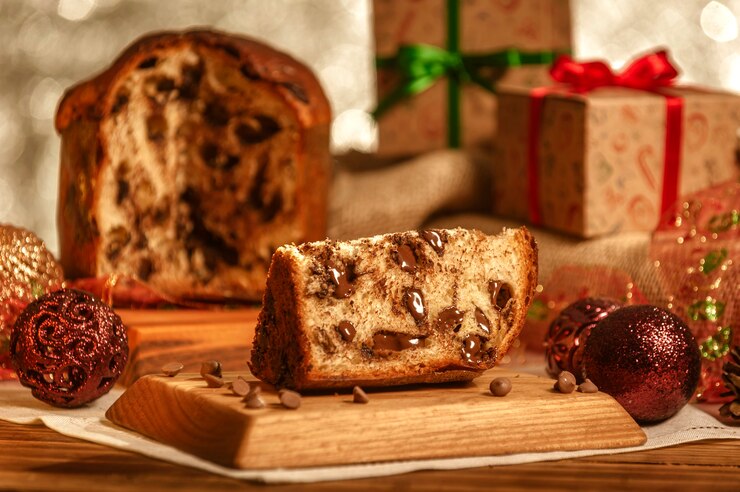 Plakje chocolade panettone op houten snijplank met kerst ornamenten