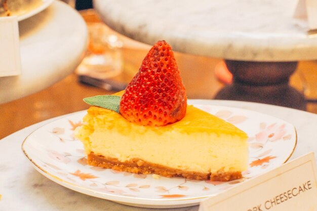 Plakje heerlijke enkele aardbeiendressing bovenop cheesecake op vintage bord