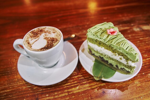 Plakje matcha-theecake met een kopje latte-koffie