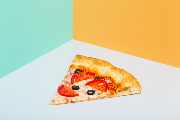 Plakje pizza margarita op papier grijze en oranje achtergrond foto van hoge kwaliteit