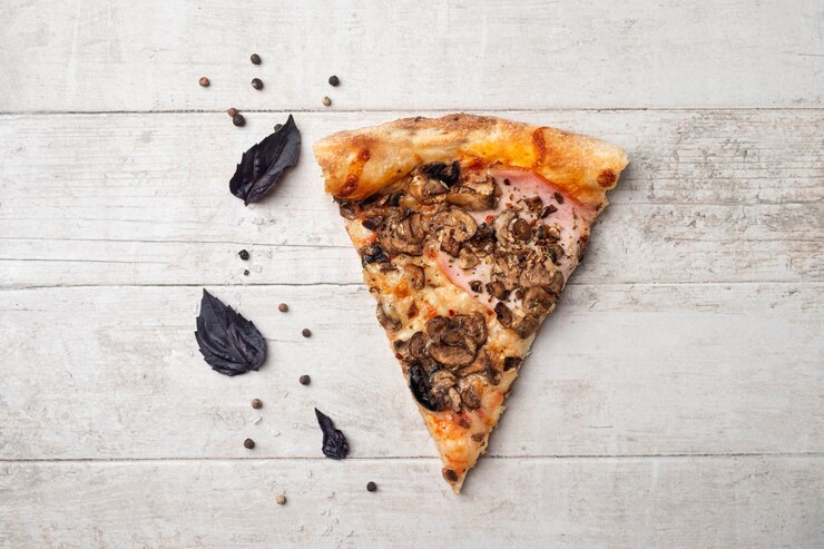 Foto plakje pizza met ham en champignons.