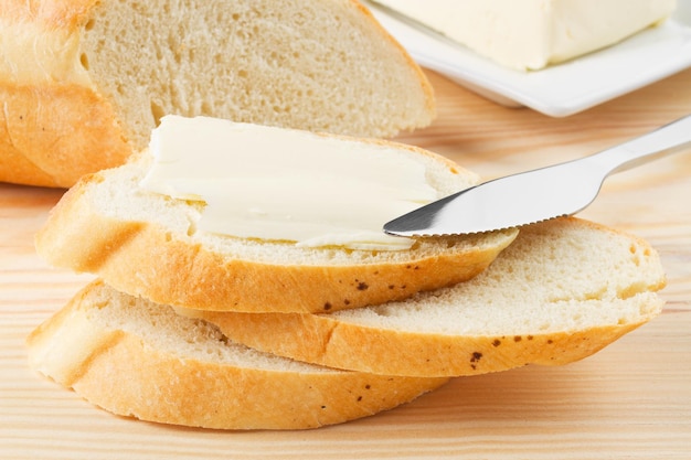 Plakje stokbrood met boter op houten bord