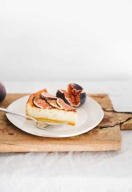 Plakje zelfgemaakte glutenvrije vijgen cheesecake op houten plank