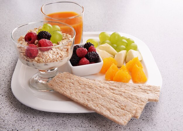 Foto plakjes fruit met bessen en muesli op tafel close-up