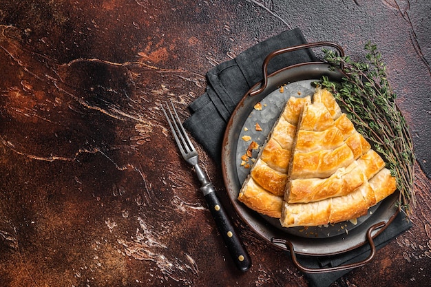 Plakjes gebakken Ronde Borek-kaastaart in keukenblad met kruiden Donkere achtergrond Bovenaanzicht Kopieer ruimte