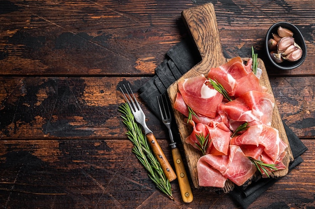 Plakjes Jamon Serranoham Of Prosciutto Crudo Parma Op Een Houten Bord Met Rozemarijn Houten Achtergrond Bovenaanzicht Kopieerruimte