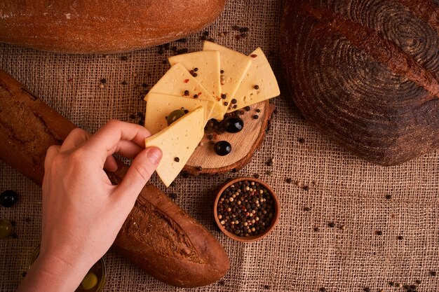 Plakjes kaas op houten bureau tussen verschillende soorten brood