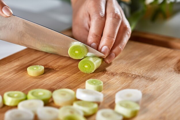 Plakjes prei op een houten bord op de keukentafel