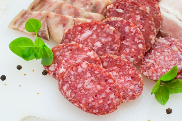 Plakjes salami en spek op een witte achtergrond