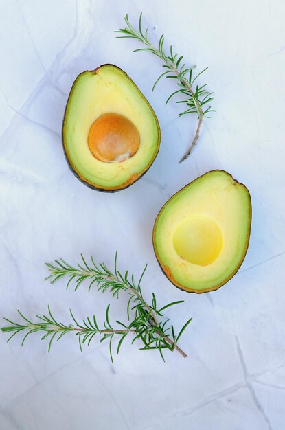 Plakjes verse avocado met kruiden en citroenen liggen op tafel op een blauw bord. Plat leggen. Bovenaanzicht.