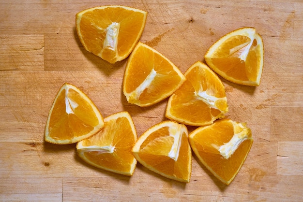 Plakjes verse biologische sinaasappel op een houten snijplank.