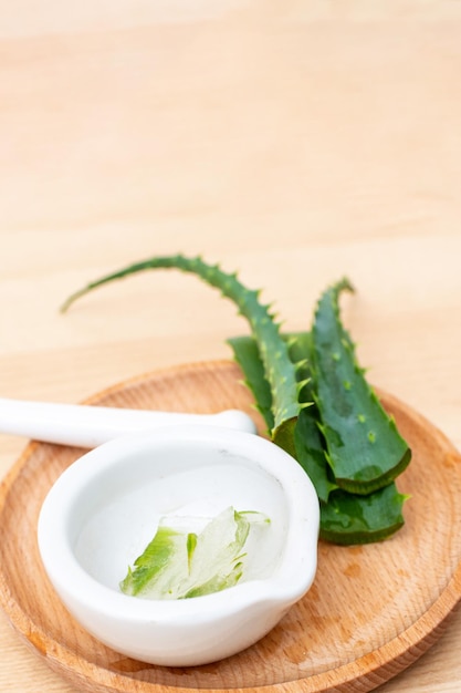 Plakken van een aloë vera blad en een keramische vijzel met transparante gel voor medicinale doeleinden huidbehandeling en cosmetica