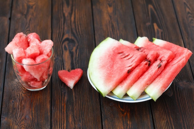 Plakken van watermeloen op plaat en glas met gevormd hart