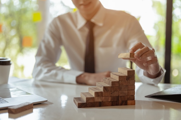 Plan en strategie in businessrisk-concepthand van de mens heeft een houten blok opgestapeld en gestapeld