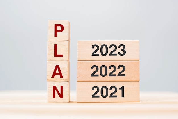 PLAN tekst met 2023, 2022 en 2021 houten bouwstenen op tafel achtergrond. Risicobeheer, resolutie, strategie, oplossing, doel, nieuwjaar, nieuwe jij en gelukkige vakantieconcepten