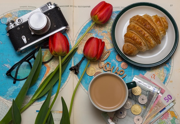 Plan van reis. achtergrond - wat te nemen voor een reis. kaart, retro camera, geld, munten, croissant, koffie, tulpen, liefde, Eiffeltoren, zonnebril