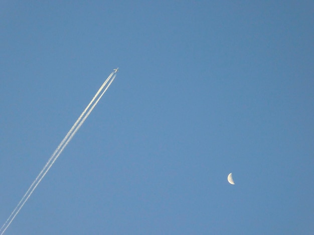 Plane in the blue sky with moon