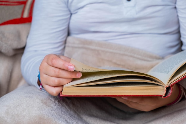 本のページを渡すことによって女の子の手から飛行機の詳細 World Book Day Child Reading