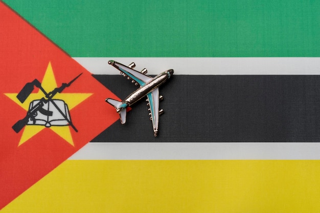 Photo plane over the flag of mozambique the concept of journey