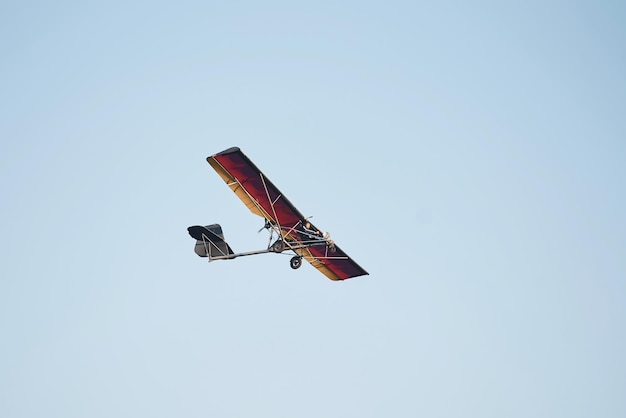 昼間の雲ひとつない空を高く飛ぶ飛行機男性パイロット