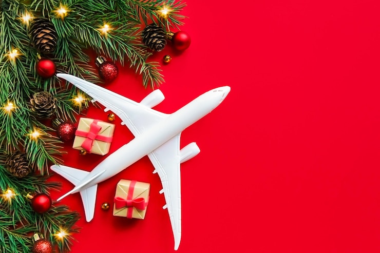 Photo plane gift box christmas decoration on red background christmas avia travel